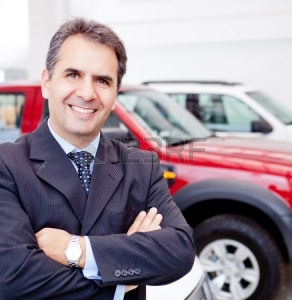 12619793-business-man-working-at-a-car-dealer-smiling